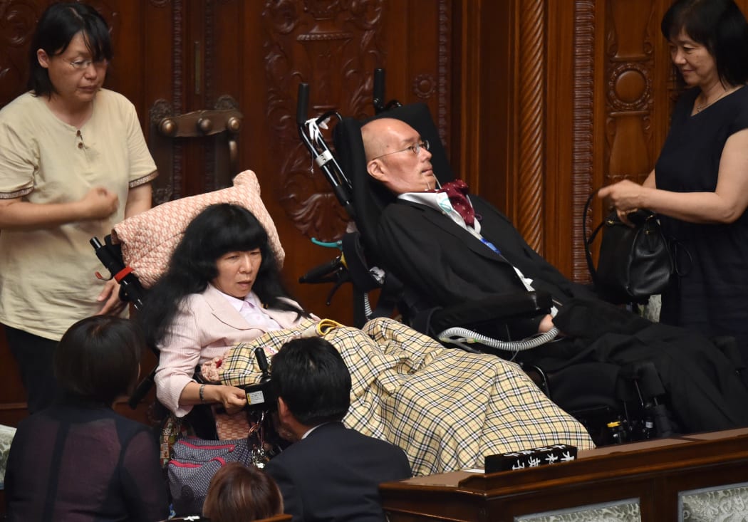Japanese lawmakers Eiko Kimura and Yasuhiko Funago prepare to leave after the opening ceremony of a session at the Upper House plenary hall in Tokyo on 1 August, 2019.