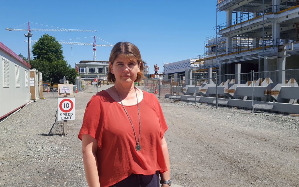 Lisa Goodman stands in road with construction behind