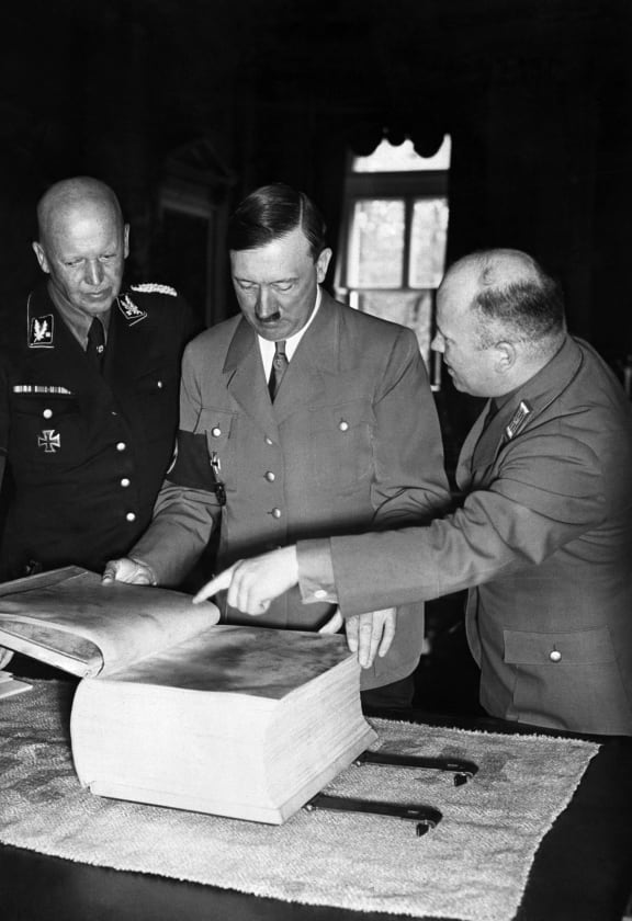 Adolf Hitler looks at an edition of Mein Kampf published on parchment.
