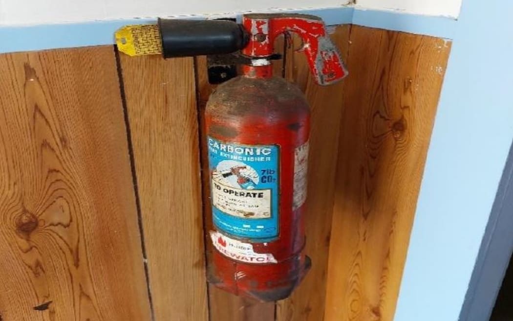 An image from the Spa Lodge report of a fire extinguisher on the wall in the escape route.
