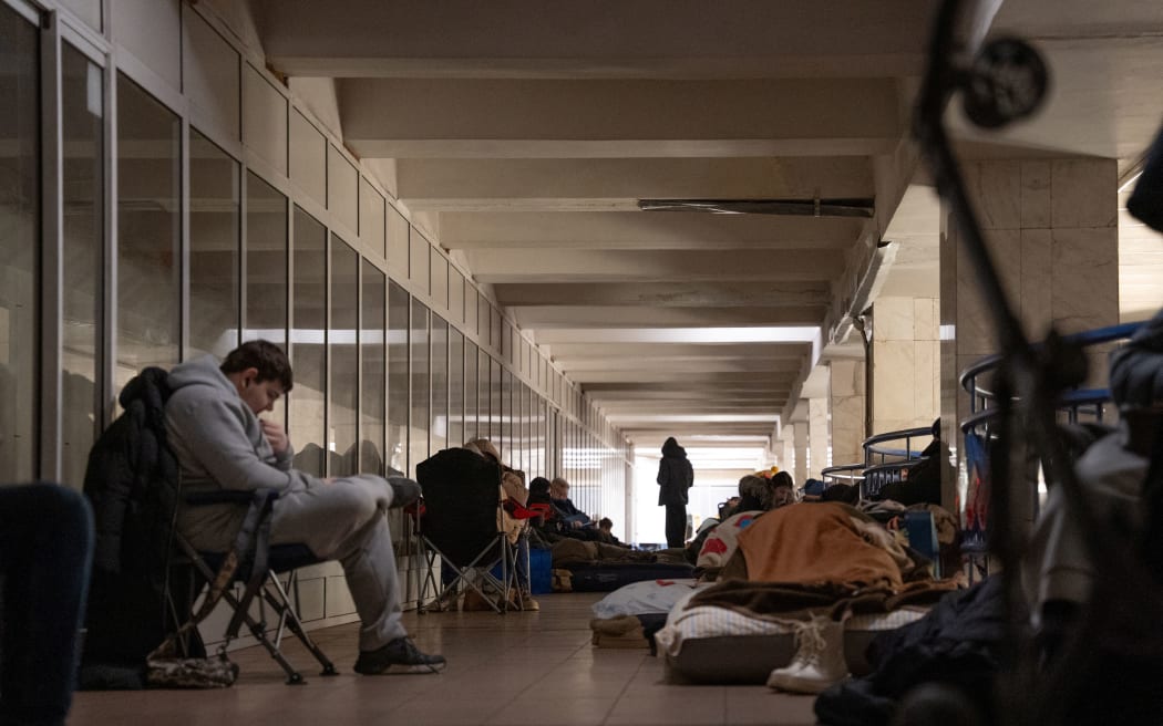 People take shelter at a metro station during Russian air attacks in Kyiv on December 27, 2025.