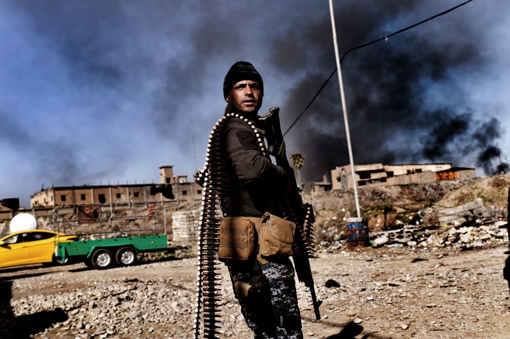 A member of Iraq's elite Rapid Response Division holds position in the northern city of Mosul as they continue the offensive to retake the city's western half from Islamic State (IS).