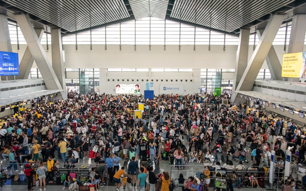 Passengers wait for information about their flights at terminal 3 of Ninoy Aquino International Airport in Pasay, Metro Manila on January 1, 2023.