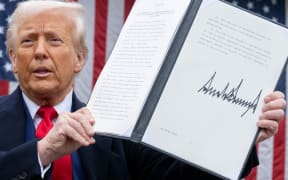 US President Donald Trump holds a signed executive order after delivering remarks on reciprocal tariffs during an event in the Rose Garden entitled "Make America Wealthy Again" at the White House in Washington, DC, on April 2, 2025. Trump geared up to unveil sweeping new "Liberation Day" tariffs in a move that threatens to ignite a devastating global trade war. Key US trading partners including the European Union and Britain said they were preparing their responses to Trump's escalation, as nervous markets fell in Europe and America. (Photo by SAUL LOEB / AFP)