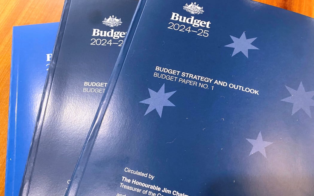 This picture taken on May 14, 2024 shows copies of the Australian government’s budget papers on a desk in Parliament House, Canberra. Australia touted plans to become a "renewable energy superpower" in an annual budget, but the government's books also laid bare the depth of the economy's dependence on mining and fossil fuels. (Photo by STEVEN TRASK / AFP)
