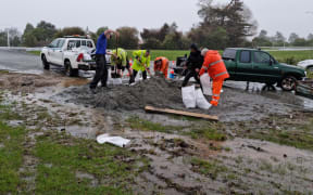Residents and Westreef personnel filling sandbags by Buller River.