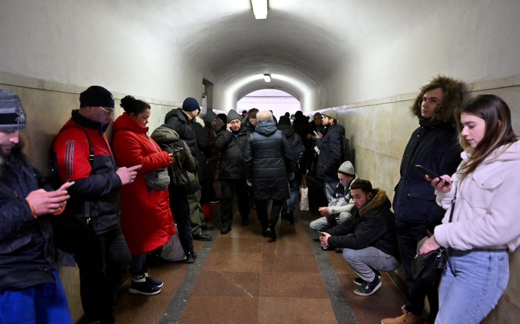 Residents take shelter in a metro station during an air strike alarm on the eve of Orthodox Christmas, in the Ukrainian capital of Kyiv on January 6, 2022, amid the Russian invasion of Ukraine. - A temporary unilateral Russian ceasefire ordered by Russian President during Orthodox Christmas was due to have taken effect in Ukraine at 0900 GMT on January 6, 2023. Dismissed by Ukraine as an empty gesture and an attempt by Moscow to gain time to regroup its forces, the ceasefire is due to last until 2100 GMT on January 7, 2023.