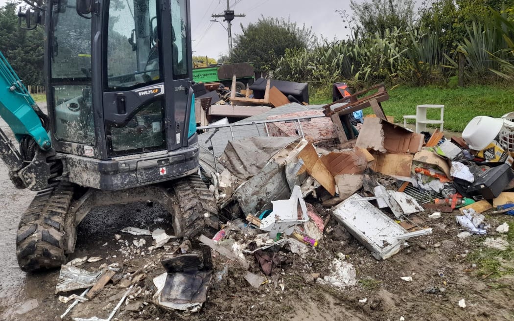 Piles of wet, smelly furniture, carpets, toys, and gib line the roads in Waiohiki, Napier after Cyclone Gabrielle.