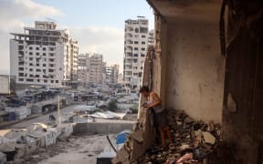 A Palestinian boy checks the damage following an Israeli strike that targets an apartment in western Gaza City, on 2 September, 2025.
