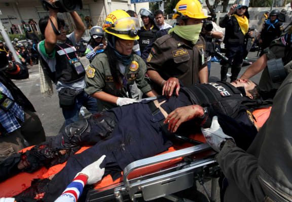 Members of a rescue team evacuate an injured policeman.