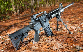 19805786 - semi automatic black rifle on a pine needle and forest background
