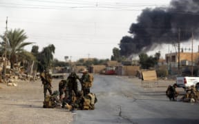 Iraqi members of the Hashed al-Shaabi (Popular Mobilisation units) in the city of al-Qa'im, in Iraq's western Anbar province near the Syrian border fight remnant pockets of Islamic State jihadists.