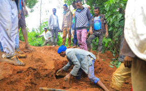 This grab made from a handout footage released by the Gofa Zone Government Communication Affairs Department on July 22, 2024, shows people looking for victims at the bottom of a landslide that occurred in the Geze-Gofa district. At least 146 people died in a landslide in southern Ethiopia on July 22, 2024, after heavy rain, according to a provisional toll that could rise further, the local authorities announced the day after.