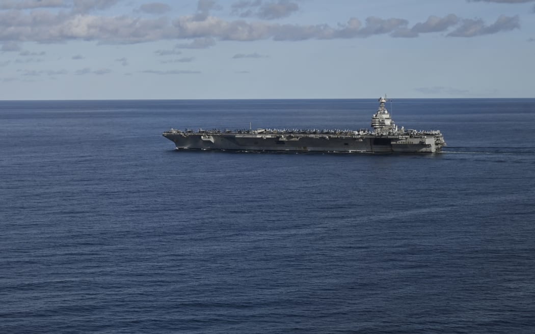 (FILES) The USS Gerald R. Ford, the world's largest aircraft carrier, seen in the North Sea during NATO Neptune Strike 2025 exercise on September 24, 2025 in the North Sea. Washington is deploying an aircraft carrier strike group to counter drug-trafficking organizations in Latin America, the Pentagon said on October 24, 2025, marking a massive increase in US firepower in the region. The United States launched a military campaign targeting boats allegedly used to smuggle narcotics in early September, destroying at least 10 vessels in a series of strikes. (Photo by Jonathan KLEIN / AFP)
