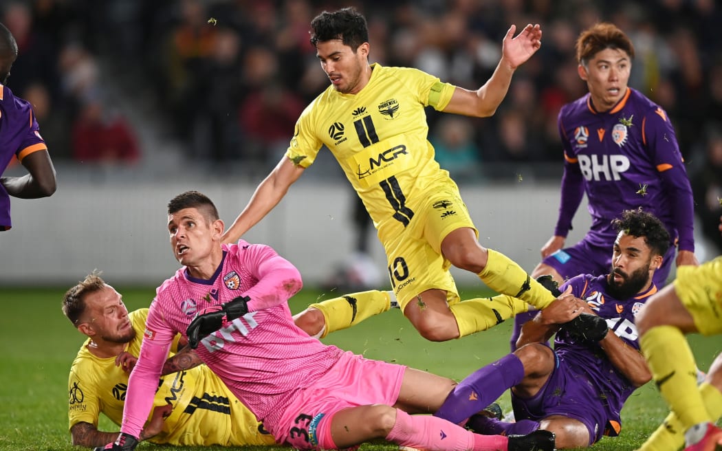 Ulises Davila leaps over Perth Glory goalkeeper Liam Reddy in their match at Eden Park earlier this season.