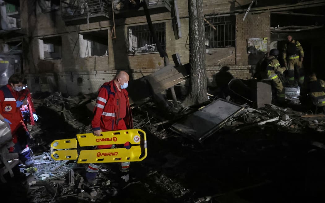 Ukrainian rescuers operate at the site of a Russian missile attack in Kyiv early on April 24, 2025, amid the Russian invasion of Ukraine. A "massive" Russian missile attack on Kyiv on April 24, 2025, killed at least nine and wounded dozens in one of the deadliest strikes on the Ukrainian capital since Moscow launched its invasion more than three years ago. (Photo by STRINGER / AFP)