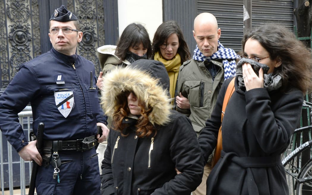French reporter Laurent leger (back-R), French cartoonist Catherine Meurisse (back, 2L) and French cartoonist Corinne Rey aka Coco (front-R) arrive to attend a meeting gathering editorial staff of 'Charlie Hebdo' and 'Liberation' on 9 January in Paris.