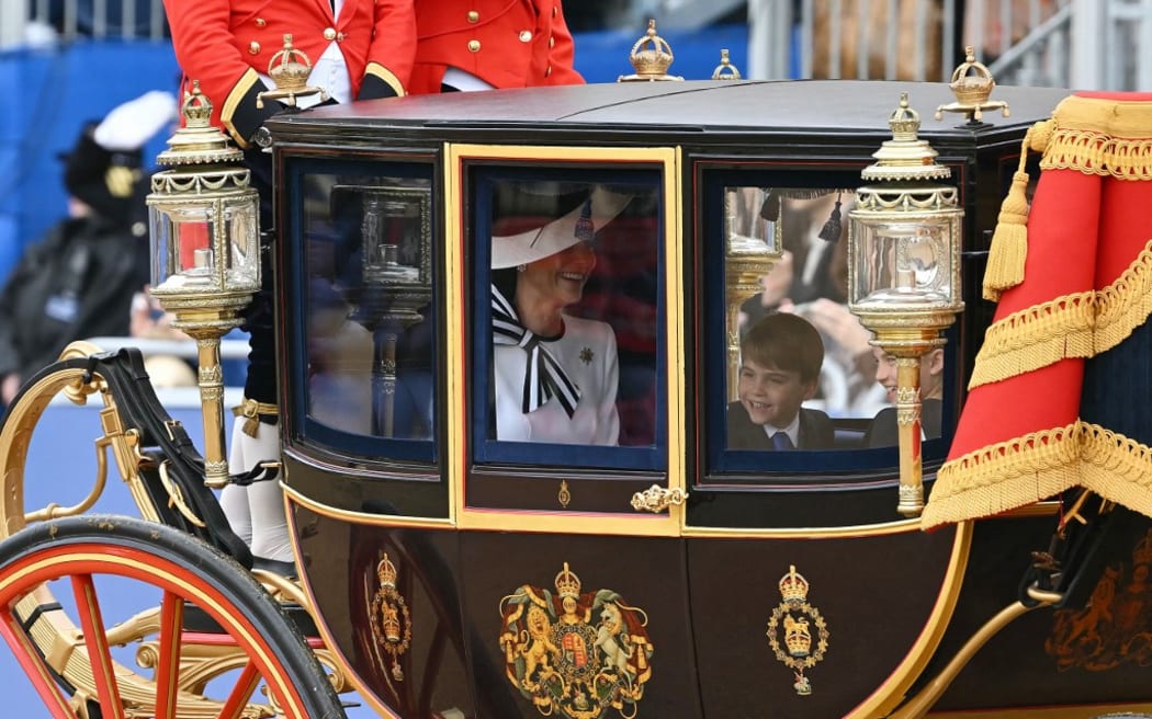 Britain's Catherine, Princess of Wales, laughs with Britain's Princess Charlotte of Wales (R) and Britain's Prince Louis of Wales (C) inside the Glass State Coach on their way to Horse Guards Parade for the King's Birthday Parade "Trooping the Colour" in London on June 15, 2024. Catherine, Princess of Wales, is making a tentative return to public life for the first time since being diagnosed with cancer, attending the Trooping the Colour military parade in central London. (Photo by JUSTIN TALLIS / AFP)
