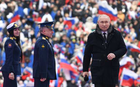 Russian President Vladimir Putin attends a patriotic concert dedicated to the upcoming Defender of the Fatherland Day at the Luzhniki stadium in Moscow on February 22, 2023. (Photo by Maksim BLINOV / SPUTNIK / AFP)