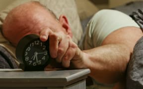 An alarm clock on a bedside table. | usage worldwide (Photo by Alexander Farnsworth / picture alliance / dpa Picture-Alliance via AFP)