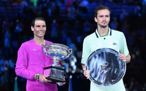 Rafael Nadal of Spain (L) holds the Norman Brookes Challenge Cup after winning the men's singles final against Daniil Medveded of Russia at the 2022 Australian Open.