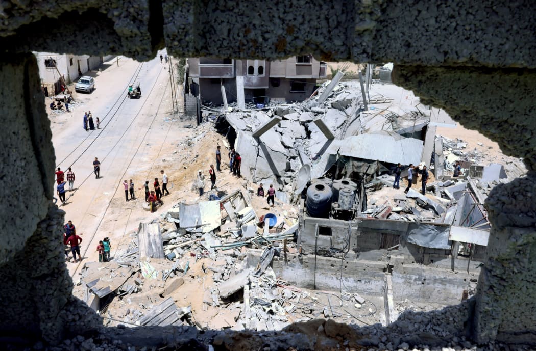 Palestinians inspect their house, after it was destroyed by an Israeli airstrike, in the city of Rafah, in the southern Gaza Strip on 16 May 2021.
