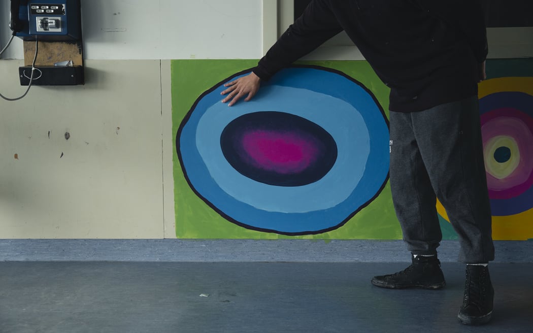 Lex with a painting of a geode that he is working on.