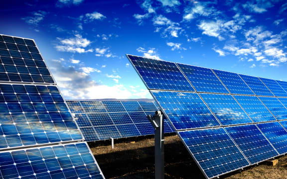 Rows of photovoltaic solar panels and blue sky with clouds