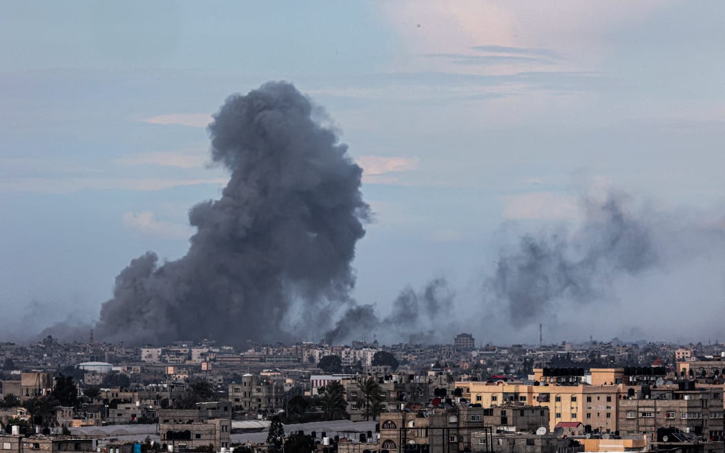 This picture taken from Rafah shows smoke billowing over Khan Yunis in the distance following Israeli bombardment on the southern Gaza Strip on February 14, 2024, amid the ongoing conflict between Israel and the Palestinian Hamas militant group.