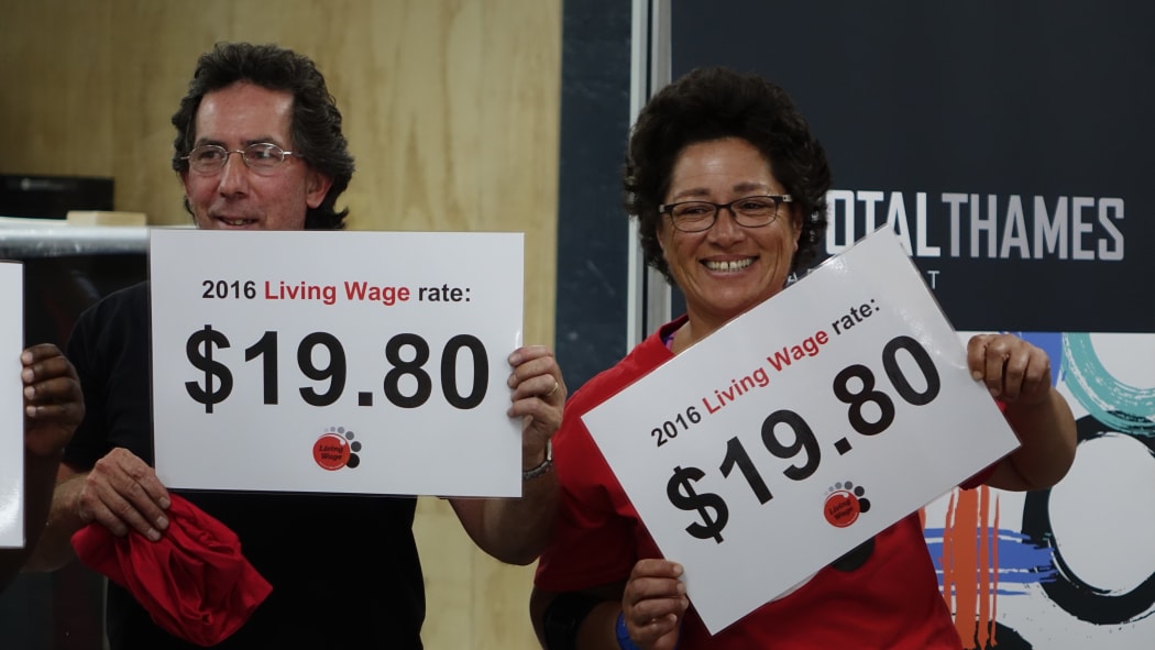 Members of Living Wage group with signs showing the 2016 living wage rate.