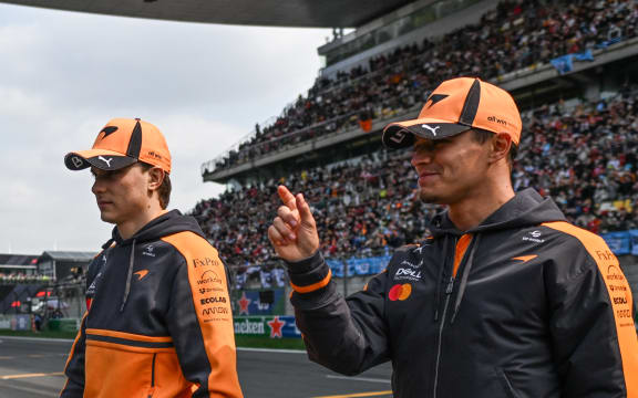 Lando Norris (R) and Oscar Piastri of McLaren walk off after the drivers' parade ahead of the Chinese Grand Prix in Shanghai. Both drivers didn't take part in the race.   (Photo by Artur Widak/NurPhoto) (Photo by Artur Widak / NurPhoto via AFP)