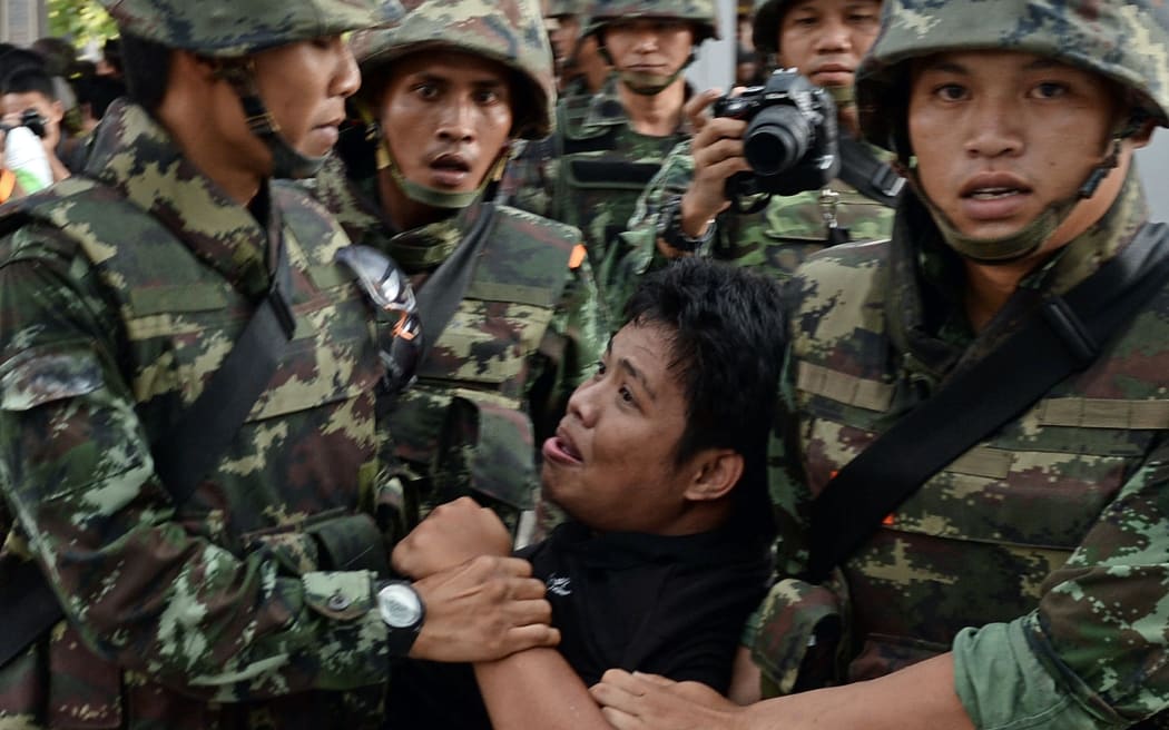Soldiers remove an anti-coup protester from a gathering in Bangkok on Saturday.
