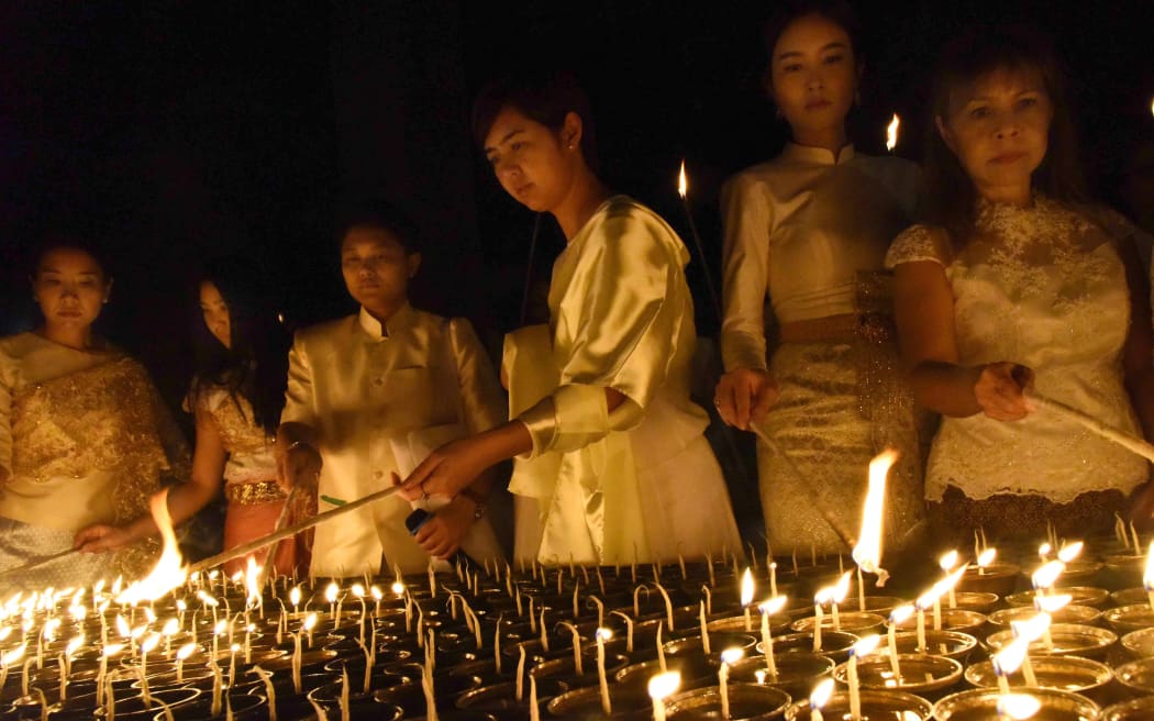 Thai devotees light candles for their late King Bhumibol Adulyadej in Bodhgaya, India.