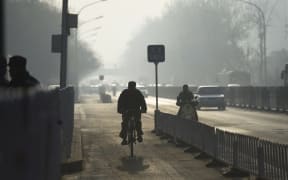 A cyclist rides in a cycle lane on a polluted morning in Beijing on April 7, 2016.