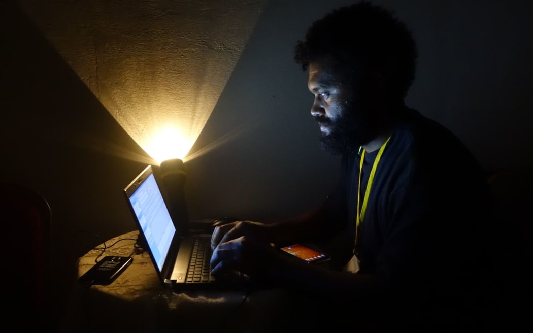 Radio New Zealand International reporter Koroi Hawkins works without power.