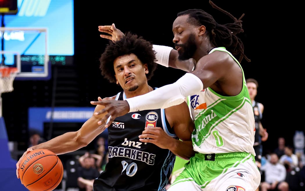 Tai Webster of the Breakers is challenged by John Brown of the South East Melbourne Phoenix.