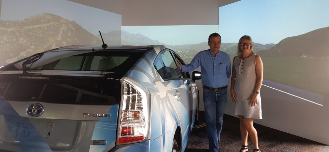 Nicola Starkey and Samuel Charlton with the car and video screens where drivers take part in road safety experiments.