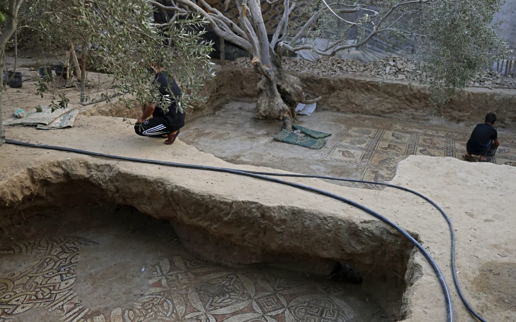 Palestinians uncover the large Byzantine mosaics found in Bureij in central Gaza Strip, which have been carefully uncovered over several months.