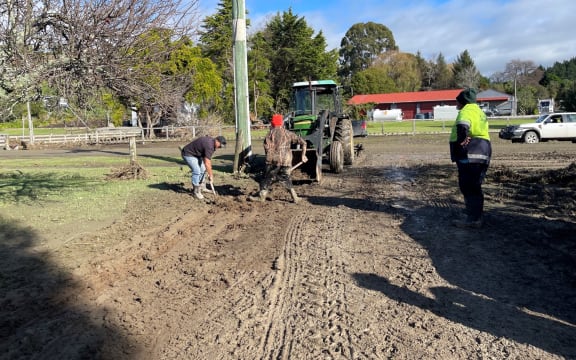 Workers start the clean-up after floods damaged roads and walkways in Tokomaru  Bay.