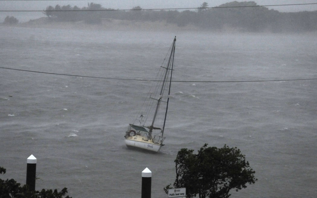 Strong winds and waves pound a boat in Cooktown on Friday.