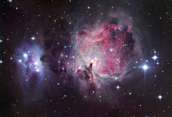 Orion nebula, optical image. North is at left. The Orion nebula can be seen with the naked eye as a fuzzy patch in the constellation Orion. It comprises several nebulae, but the brightest is M42 (pink, centre right). M43 is the small round nebula at lower centre, separated from M42 by a thin blue band of gas. M42 and M43 glow pink as the hydrogen they contain is ionised by radiation from hot young stars that recently formed inside them. In the case of M42, the stars that light it up are a group of four known as the Trapezium (just right of centre). The blue nebula NGC 1977 is at left. This nebula is not ionised, instead reflecting the light of nearby blue stars. The nebulae lie around 1500 light years from Earth. (Photo by ROBERT GENDLER/SCIENCE PHOTO LIB / RGN / Science Photo Library via AFP)