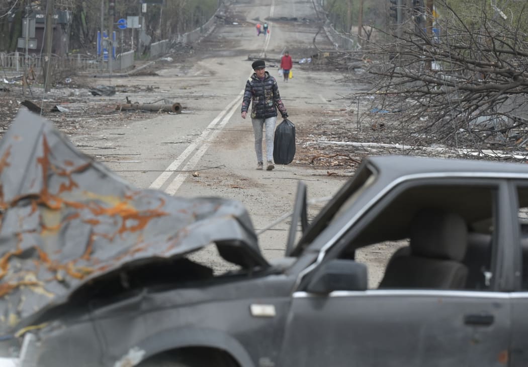 A resident walks along a street in Mariupol, trying to flee the conflict.