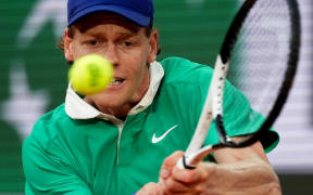 Italy's Jannik Sinner plays a backhand return to Serbia's Novak Djokovic during their men's singles semi-final match on day 13 of the French Open tennis tournament on Court Philippe-Chatrier at the Roland-Garros Complex in Paris on June 6, 2025. (Photo by Dimitar DILKOFF / AFP)