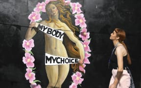 A woman walks in front of a pro-choice mural relating to the laws regarding abortion in Dublin on May 11, 2018.