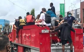 Fijian firefighters give tourists a ride to Nadi Airport amid Cyclone Cody.