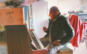 Mark Vanilau sitting at a piano