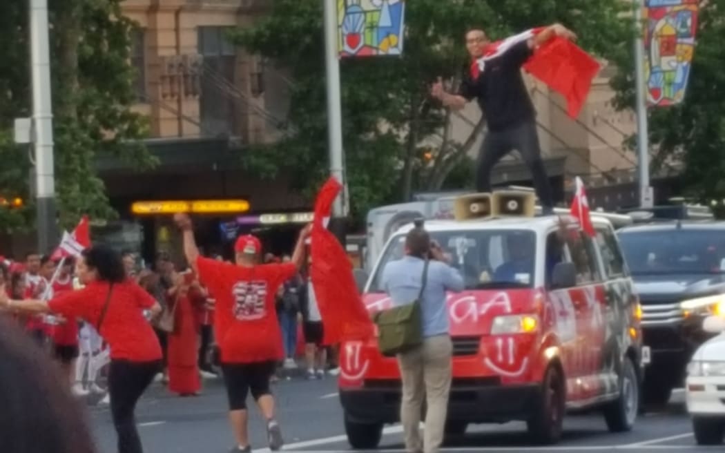 A Tonga rugby league supporter takes to the roof of a van to make his view on Saturday's semi-final known.