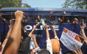 Myanmar student protesters and activists gesture from a departing police truck following a court hearing in Letpadan on April 7, 2015.