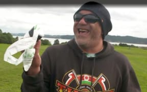 Man holding plastic bag - Dog owners adapt as some plastic poo bags phased out