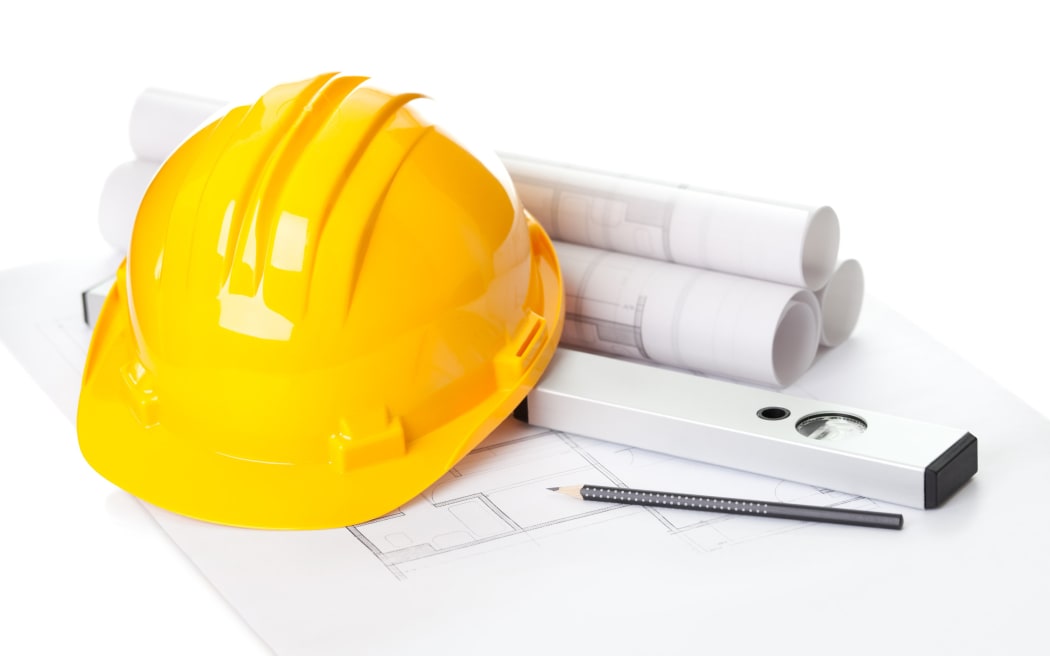 Building plans and hard hat on a table.